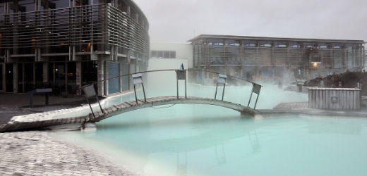 Blue Lagoon pool with a bridge going over it, the buildings in the background