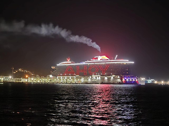 Virgin Voyages Valiant Lady anchored at Ibiza at night displaying AHOY!