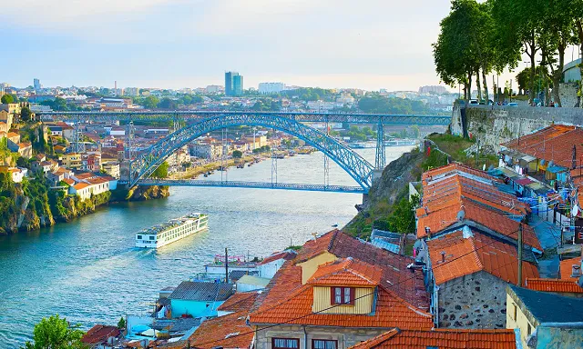 a river cruise ship sailing down the duoro river in porto